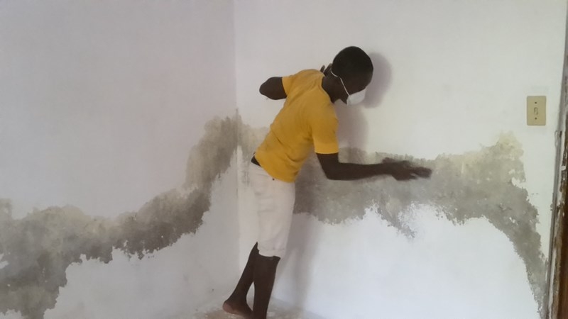Chednel un de nos jeune bénévole en train de sablé les murs avant de redonner un coup de jeune à la peinture